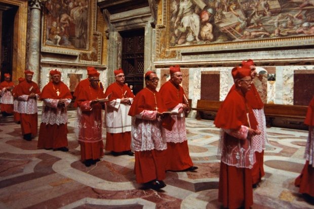 A procession of cardinals file into the Vatican