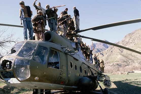 Afghan fighters on top of a destroyed Soviet helicopter, 1980 (Photo by Alain Dejean/Sygma via Getty Images)